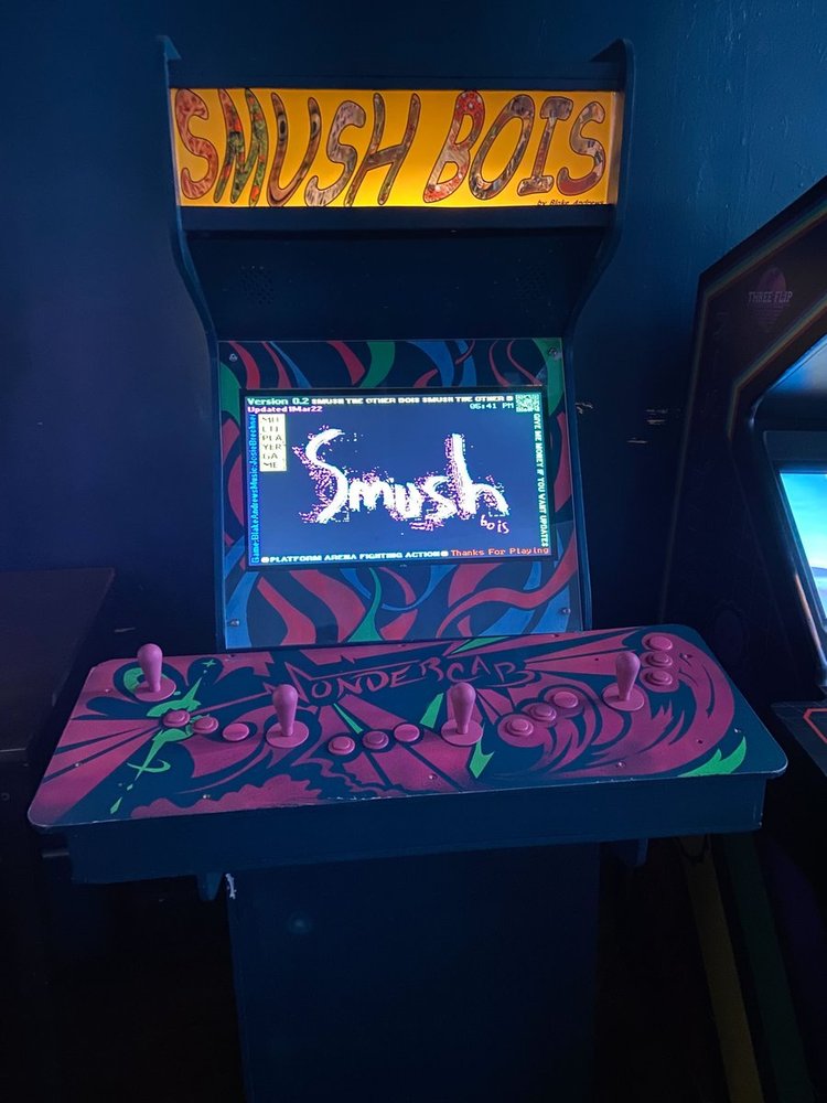 A custom arcade cabinet with 'Wondercab' printed on the control deck and 'Smush bois' on the nameplate. The display shows the Smush bois title screen.